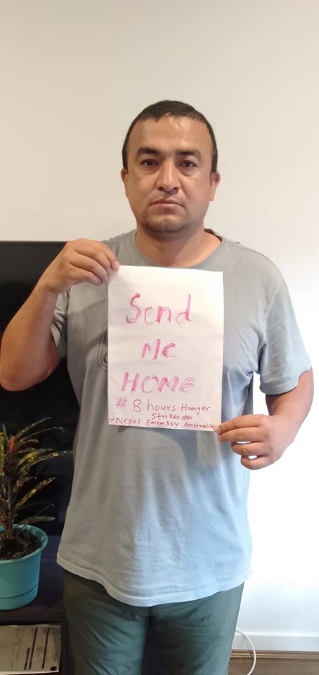 Anil Adhikari holds a placard asking he be sent home. (Image: Anil Adhikari/Facebook)